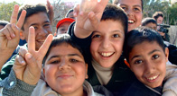 Middle Eastern children laugh, hug and show peace fingers