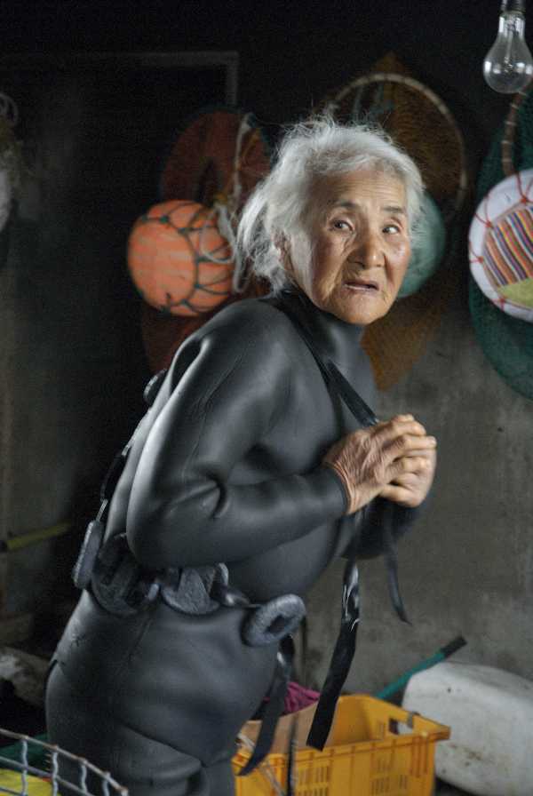 older korean woman in wetsuit getting ready to dive