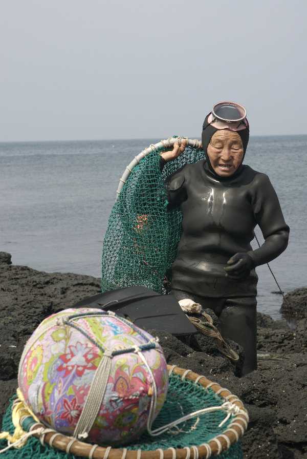 older woman getting out of the water after a dive in the sea